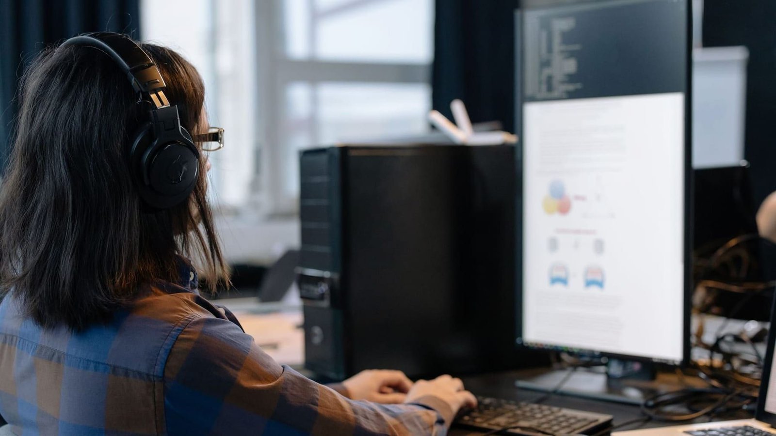 An office worker wearing a headset working in a business application on a desktop computer.