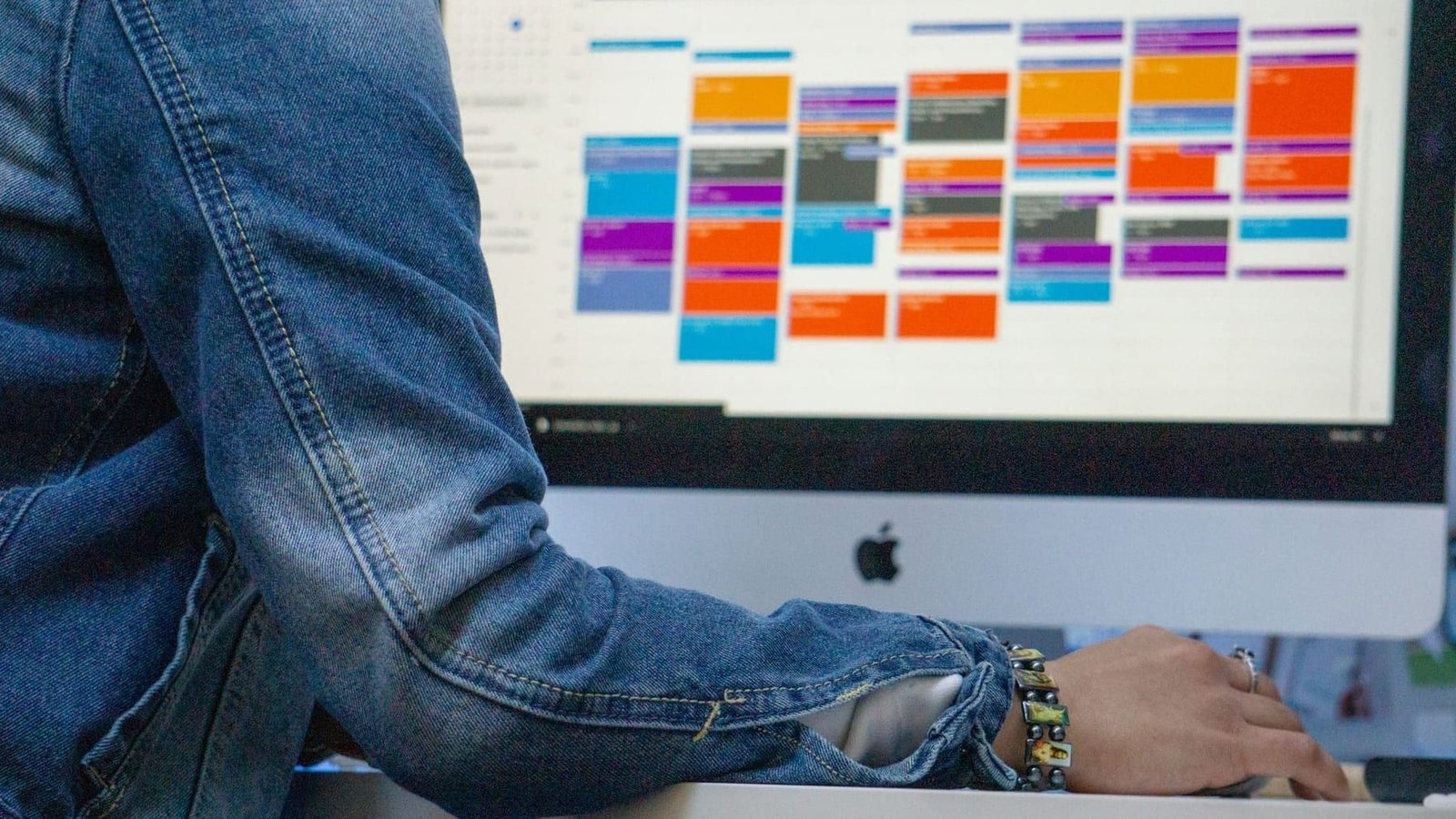 Interface screens laid out for review on a designer’s monitor during a design critique.